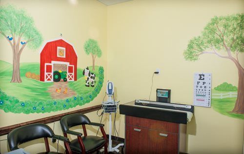 A child's exam room with a farm mural on the wall.