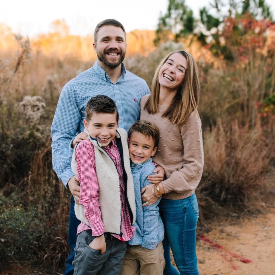 A family is posing for a picture in a field.