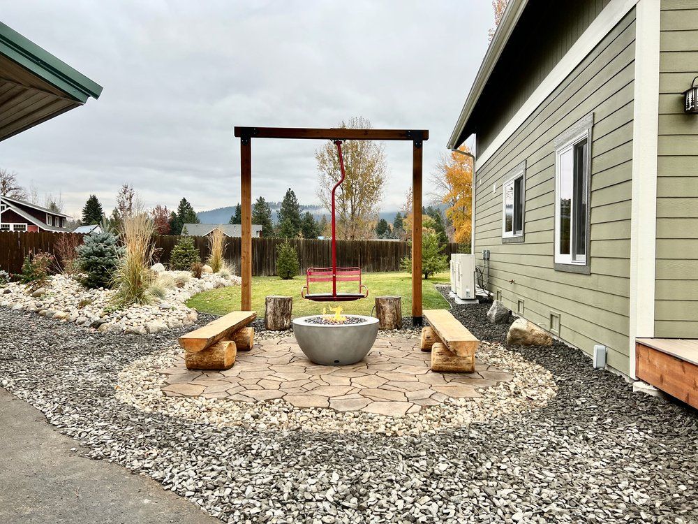 A fire pit in between two wooden benches and a chairlift swing