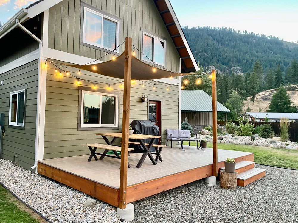 A house with a large covered patio and a picnic table on it.