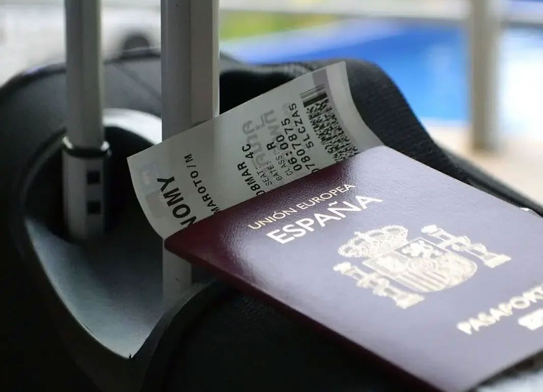 Open passport with boarding pass in an airport security tray Open passport with boarding pass in an airport security tray
