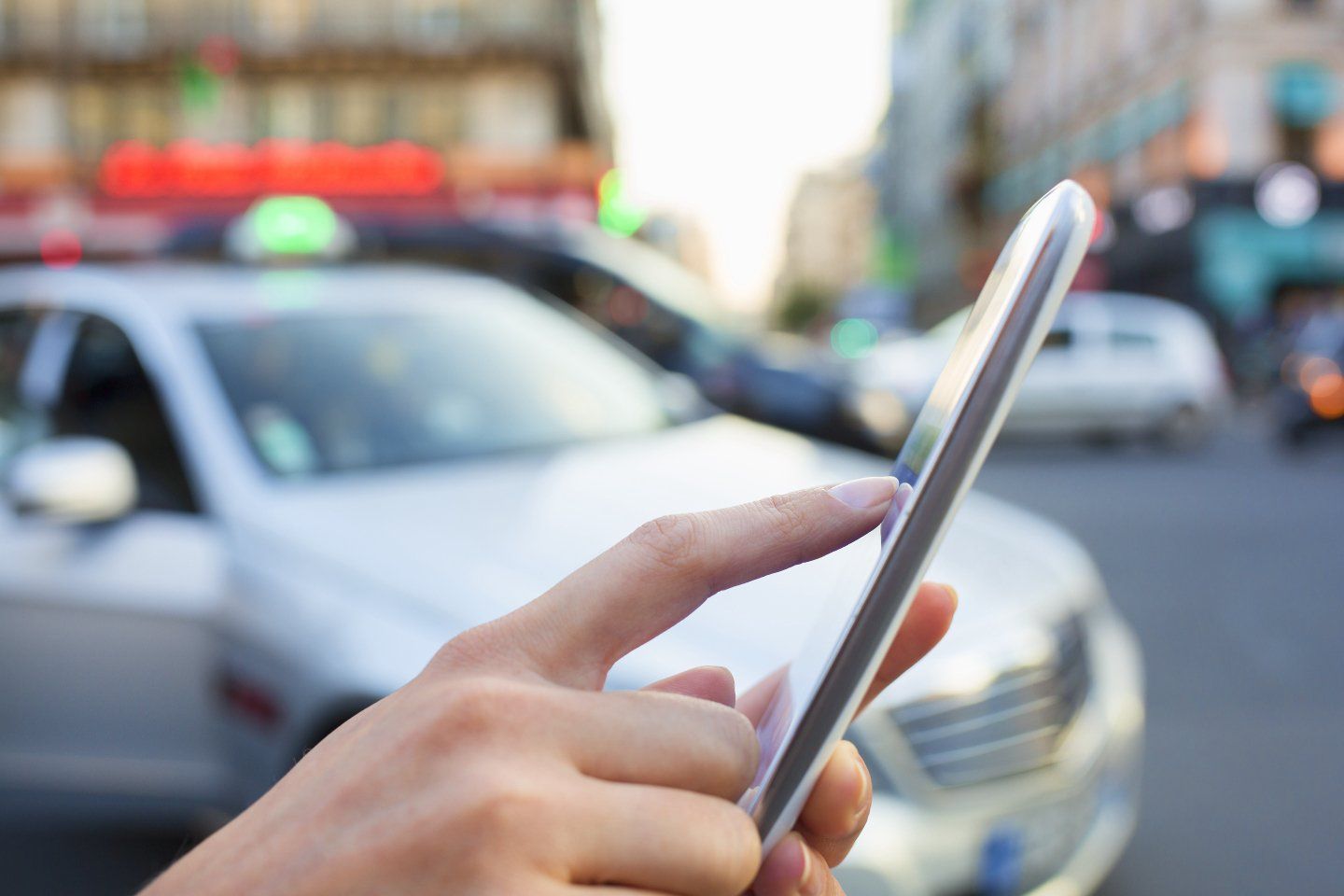 mano mentre digita numero taxi su smartphone