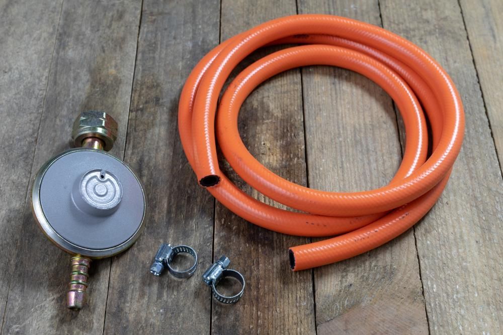 A Hose With A Valve And Clips Is On A Wooden Table — NQPT In Garbutt, QLD