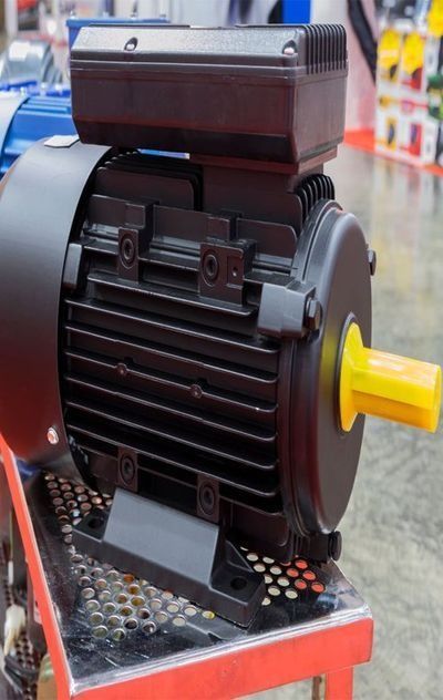 A Black Electric Motor With A Yellow Shaft Is Sitting On Top Of A Table — NQPT In Garbutt, QLD