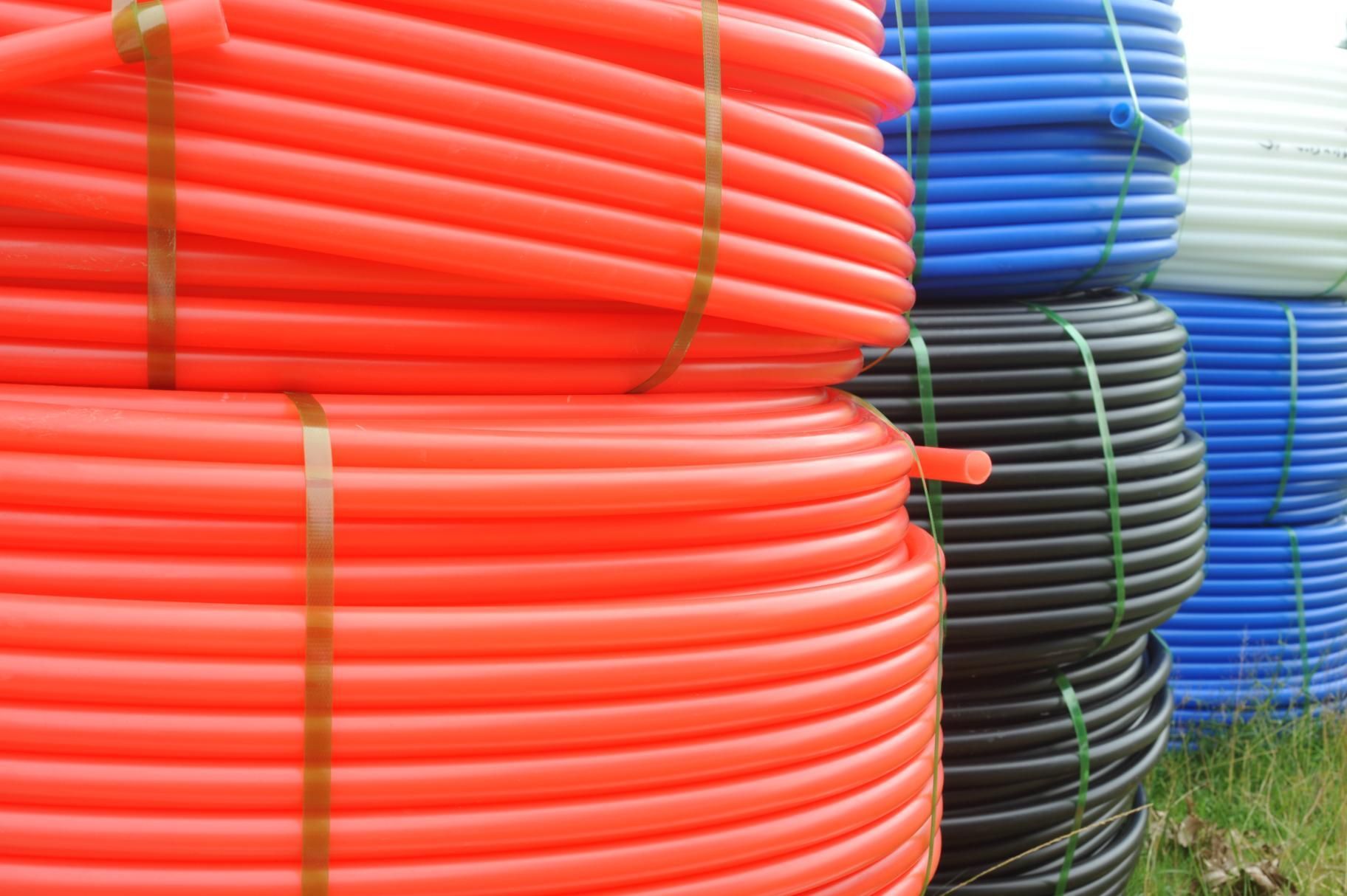 A Bunch Of Different Colored Plastic Pipes Are Stacked On Top Of Each Other — NQPT In Garbutt, QLD