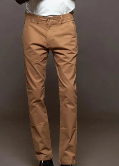 Pantalones chinos color camel en un maniquí, mostrados de frente con camisa blanca y zapatos negros.