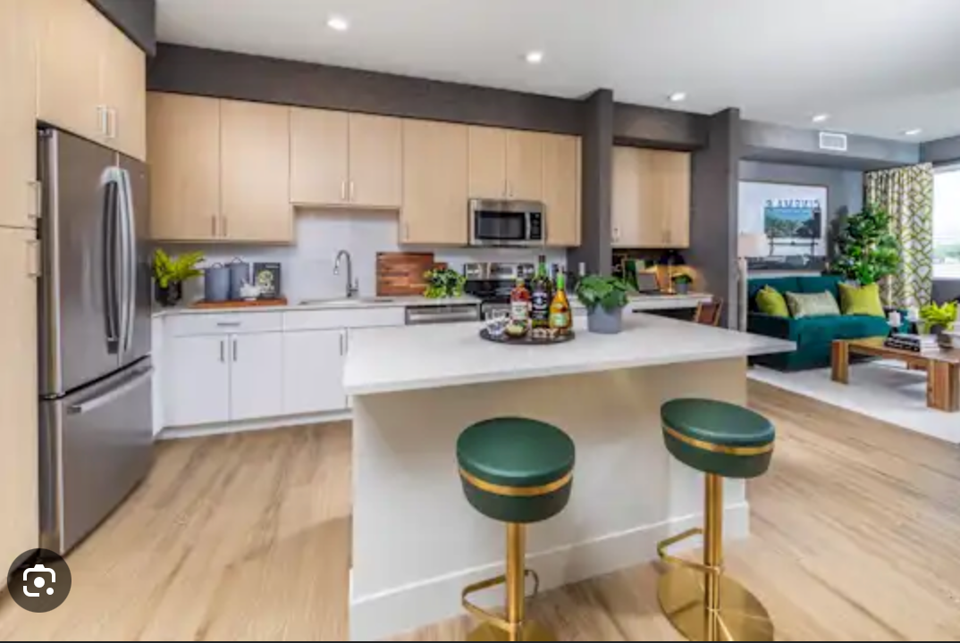 A kitchen with a large island and two bar stools