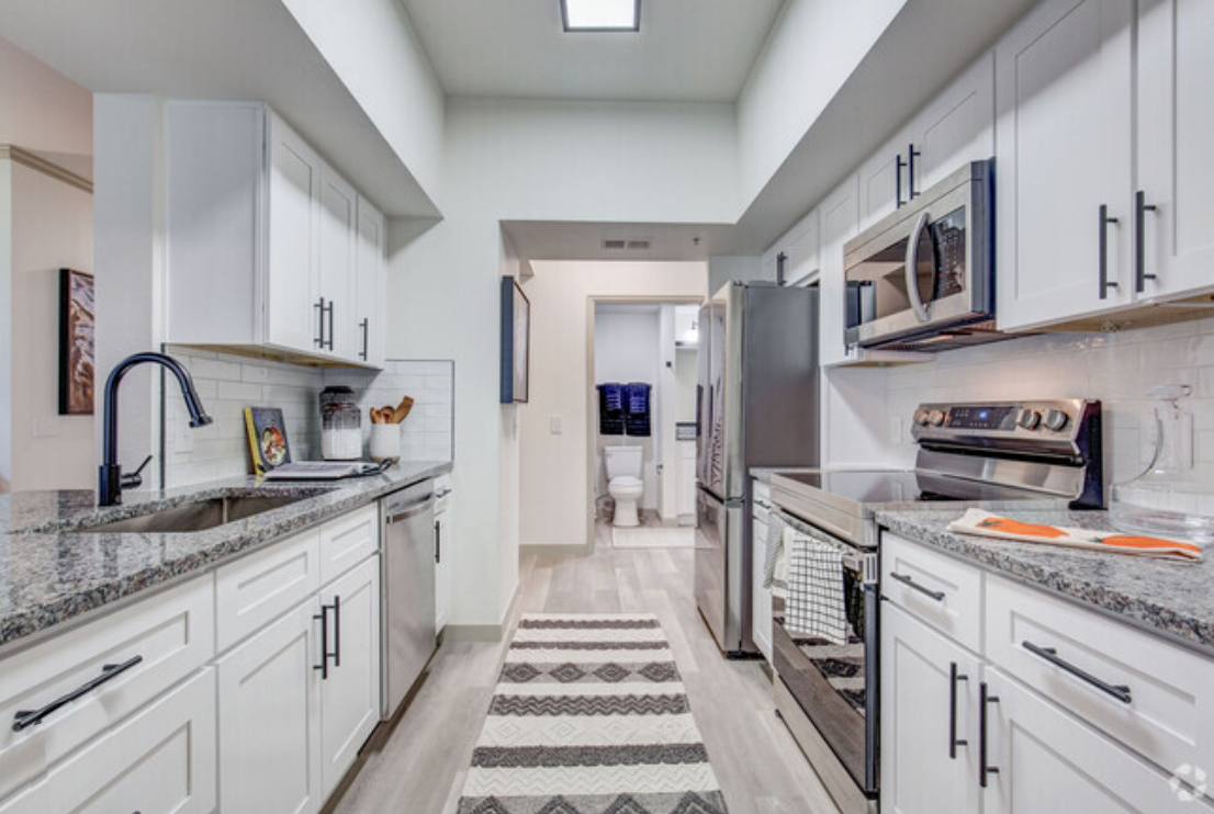 A kitchen with white cabinets and stainless steel appliances.