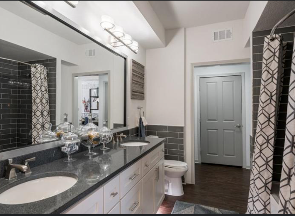 A bathroom with a toilet a sink and a mirror