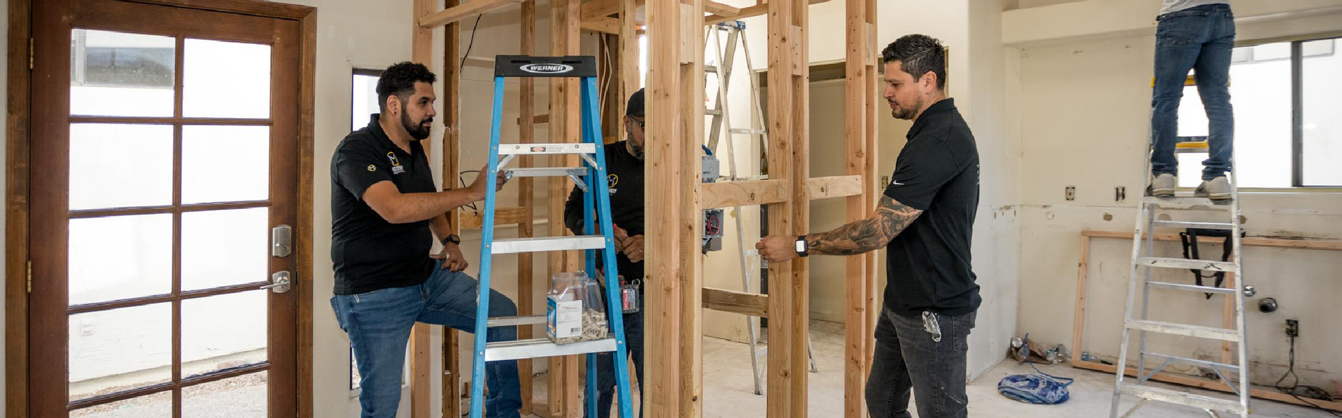 A group of men are working on a house.