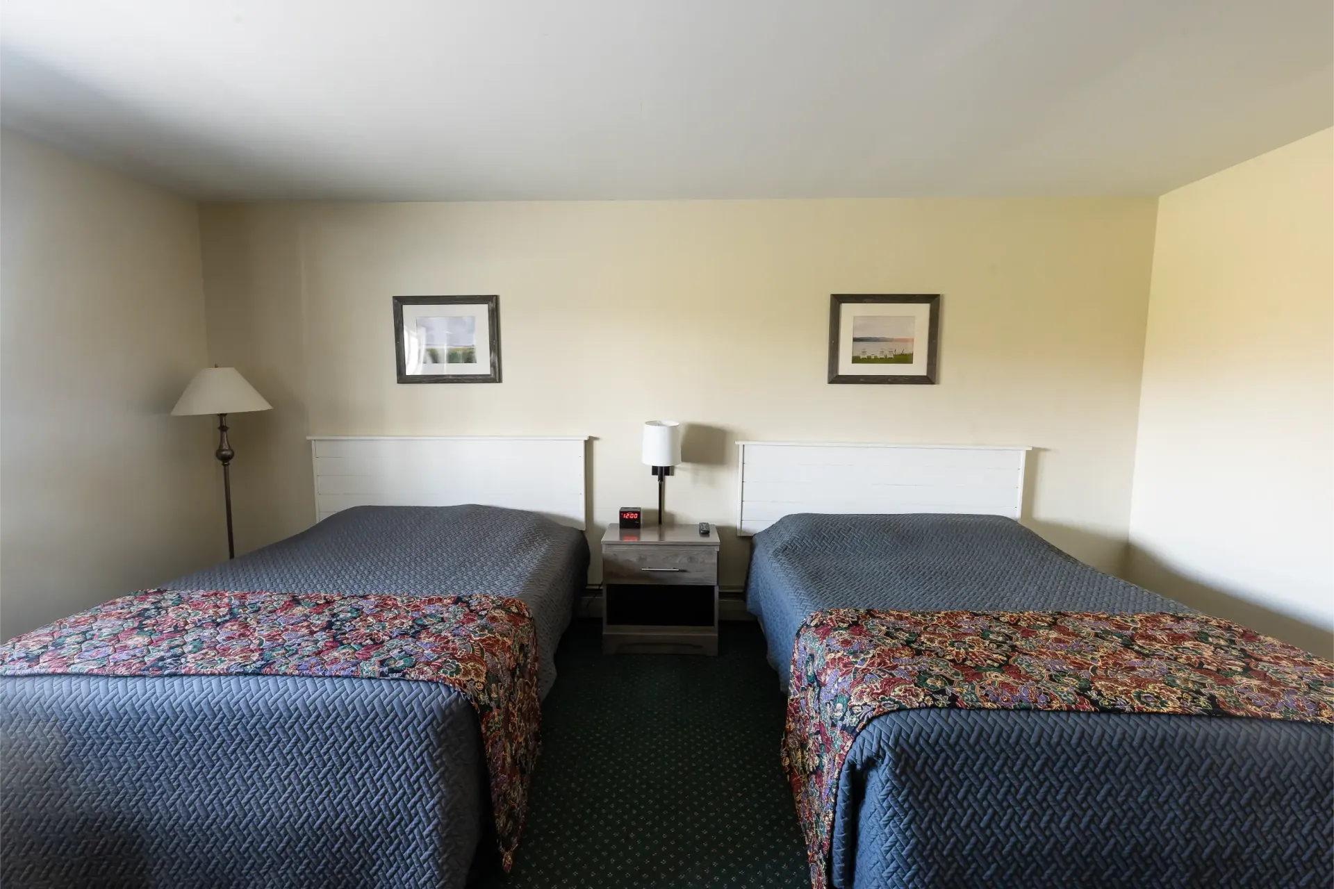 A hotel room with two beds and two lamps