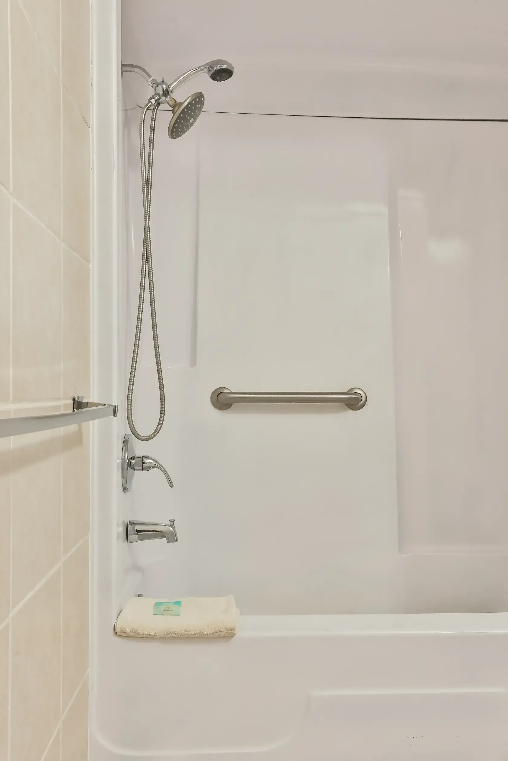 A bathroom with a bathtub , shower , and soap dish.
