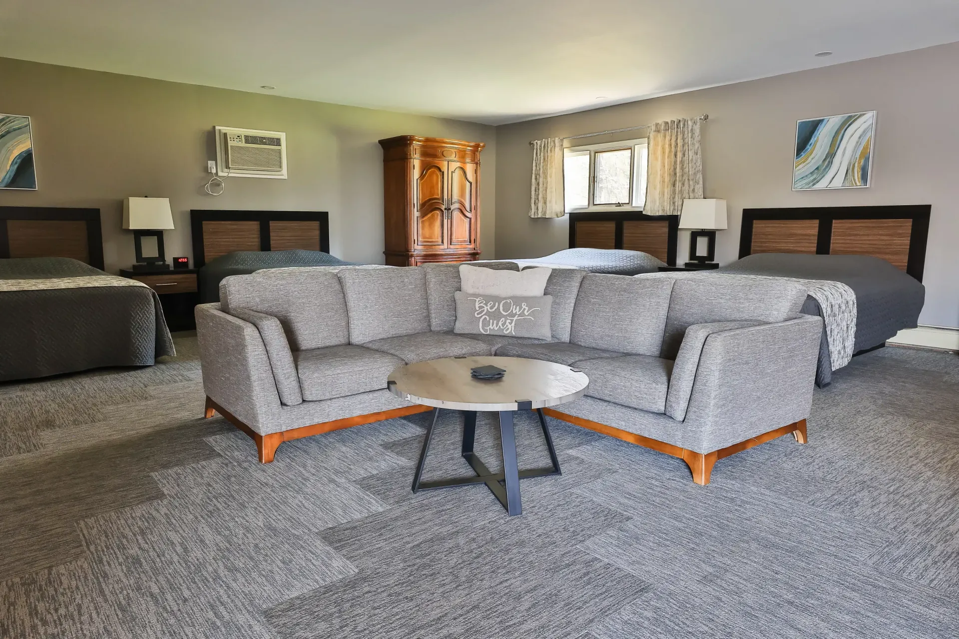 A hotel room with a couch , chairs , and a table.