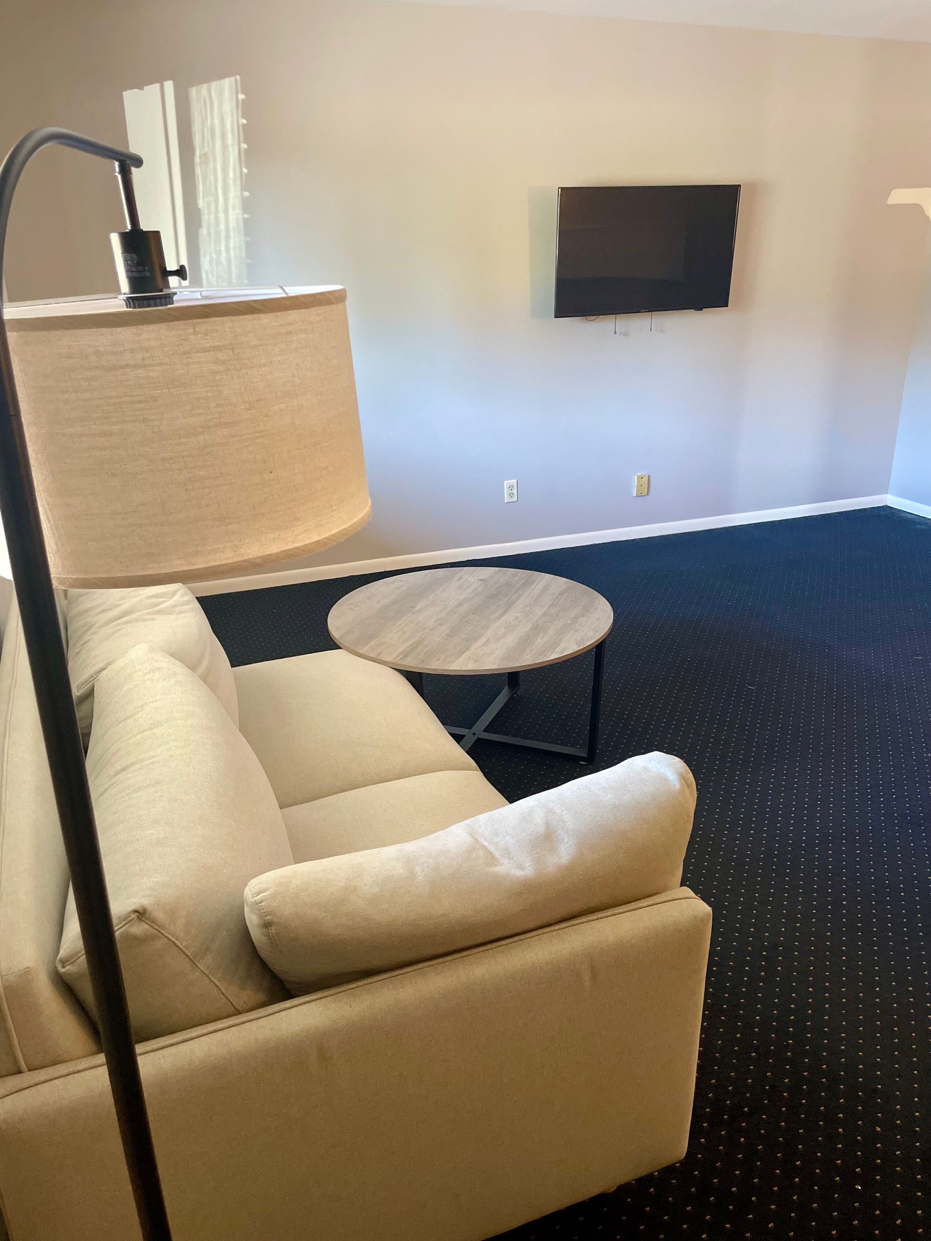 A hotel room with a microwave and a refrigerator