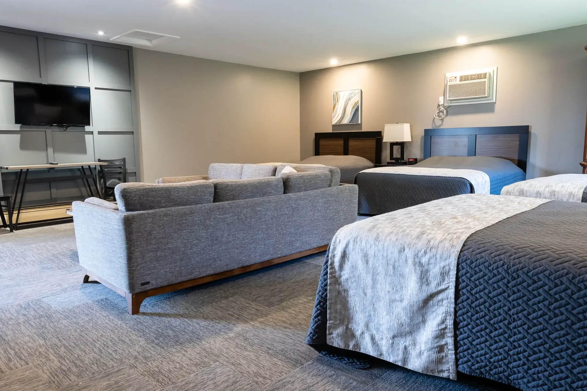 A hotel room with two beds , a couch , and a television.