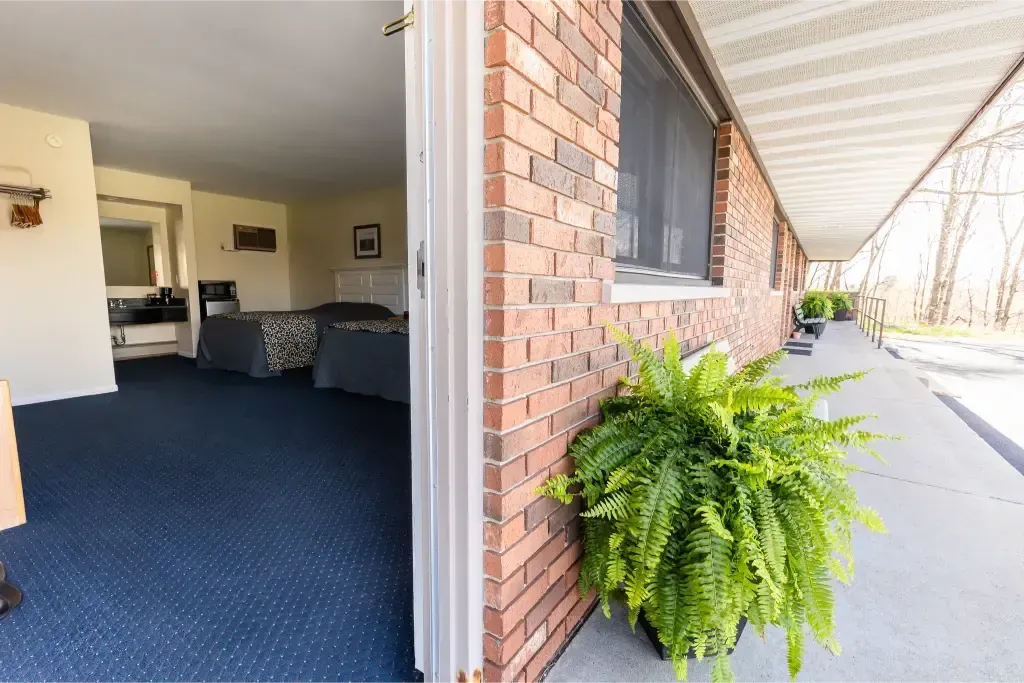 A brick building with a balcony and a potted plant in front of it.