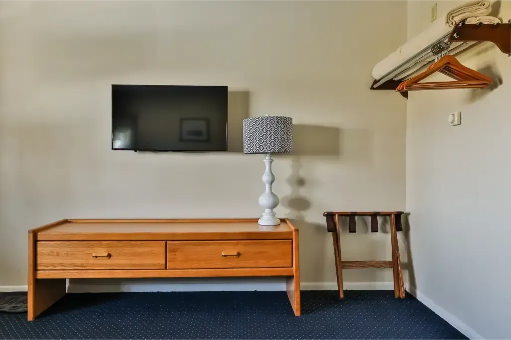 A hotel room with a flat screen tv and a lamp