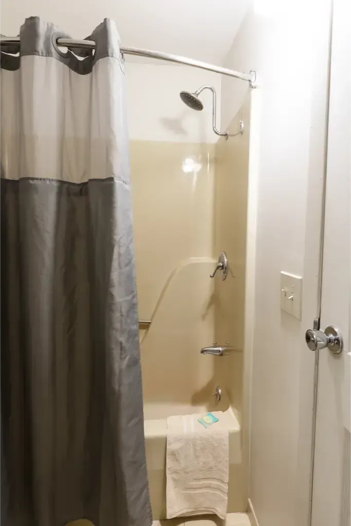 A bathroom with a shower curtain and a bathtub