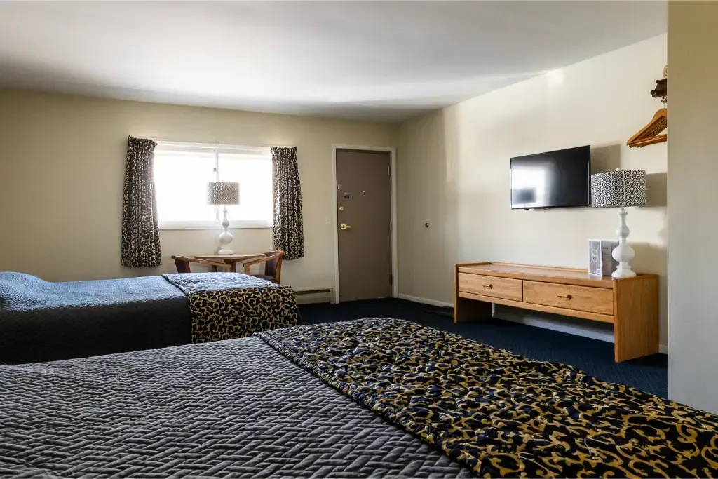 A hotel room with two beds and a flat screen tv.