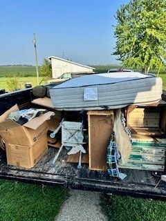 Trash Talkers crew member securing load on a dump trailer at a Kankakee County residence