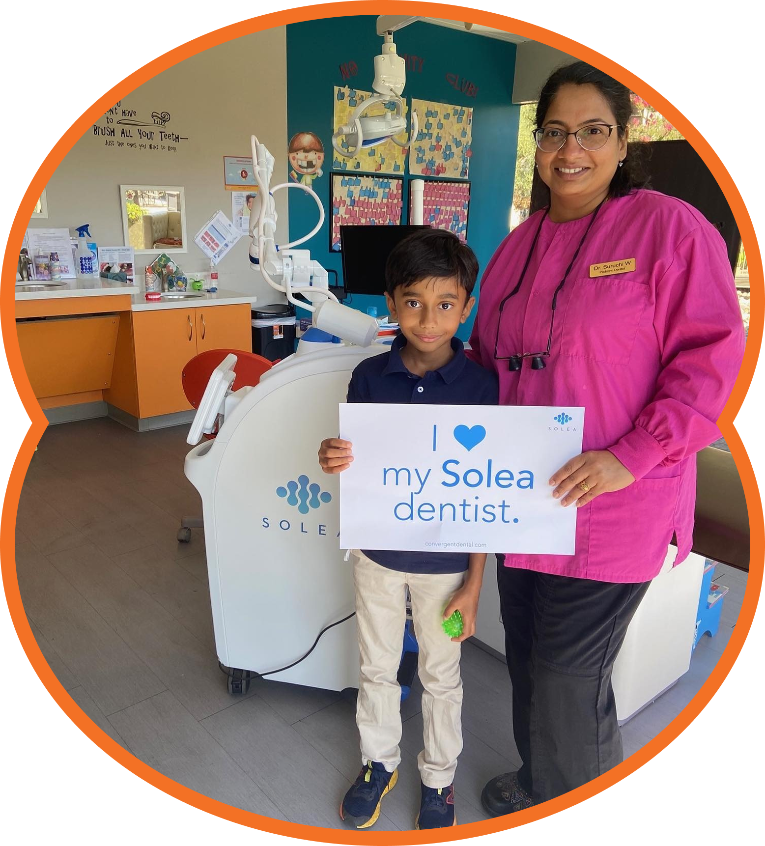 Child and dentist holding “my Solea dentist” sign in a dental clinic