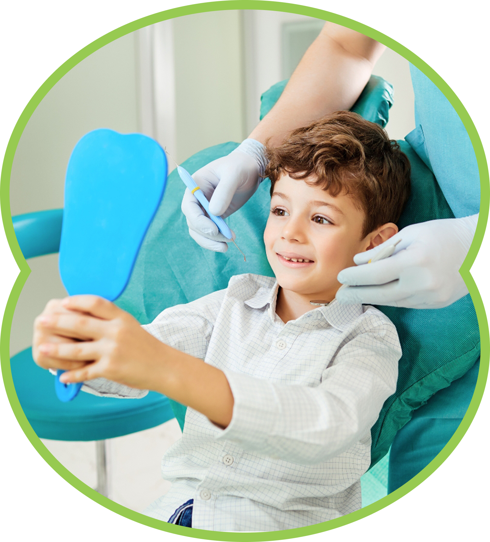 Young child smiling while holding a blue mirror during a dental exam with gloved hands nearby