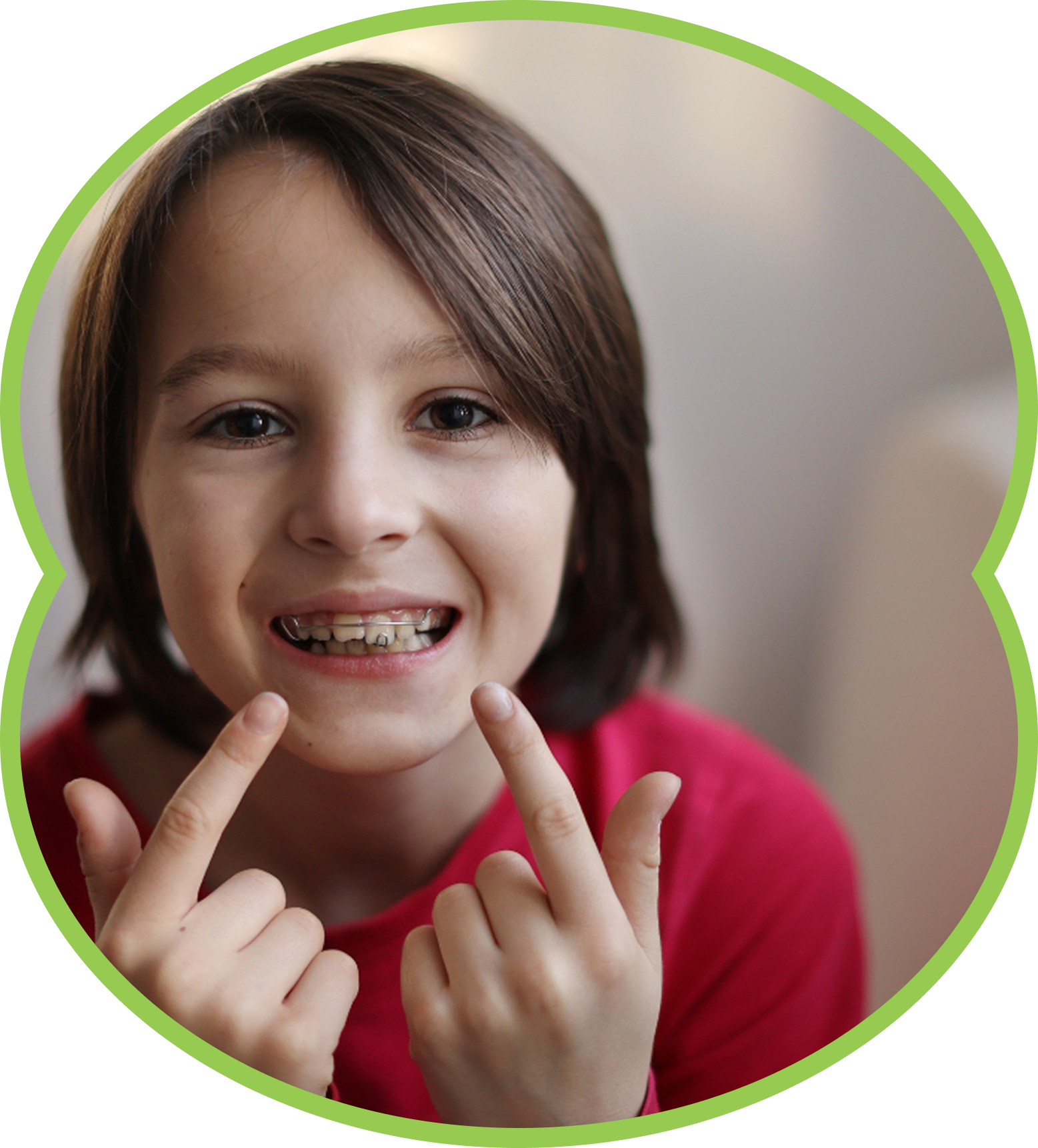 Smiling child showing braces and pointing at teeth, wearing a red shirt, framed by a green circle.
