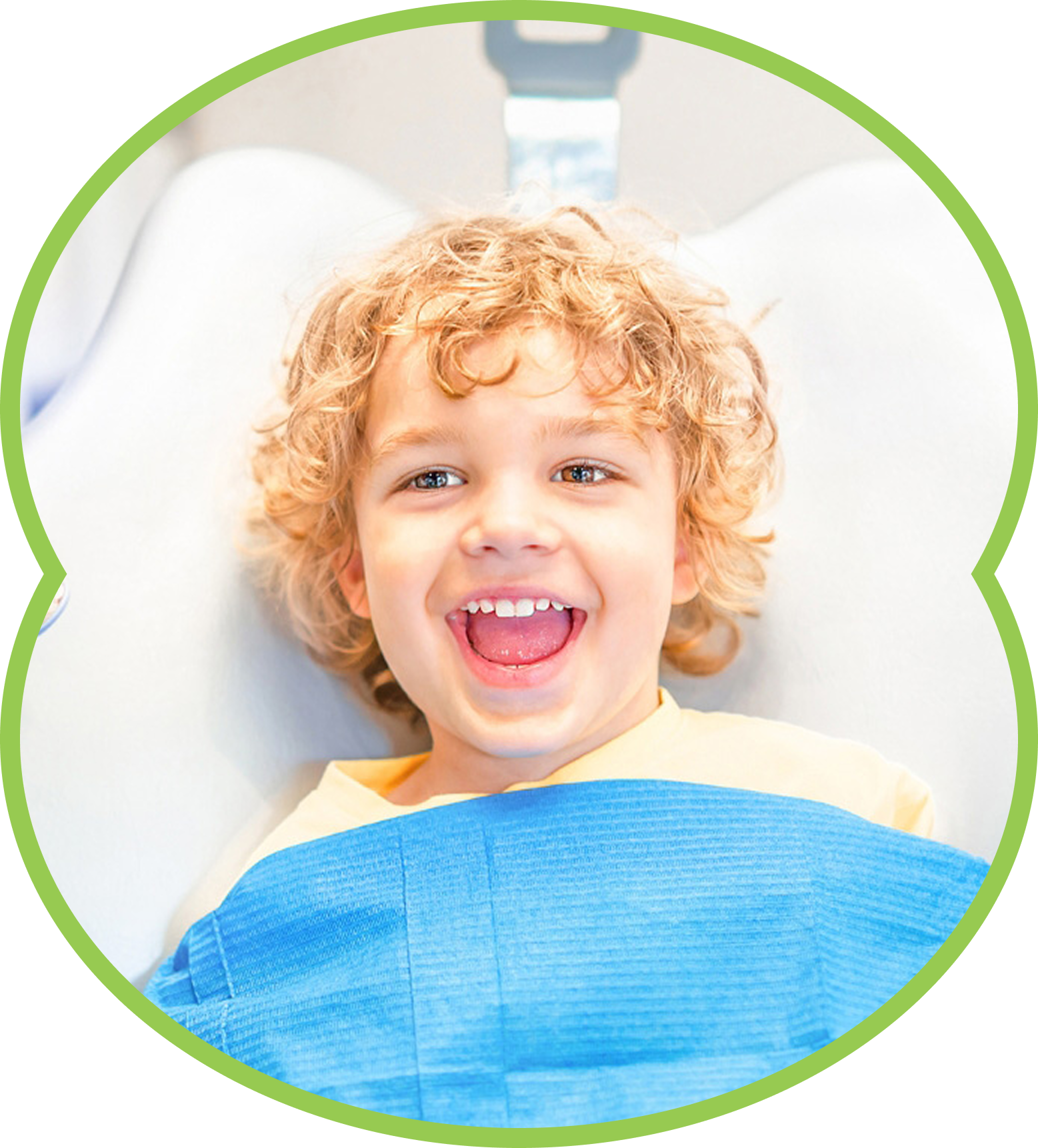 Smiling child lying in a dental chair under a blue bib, framed by a green circle