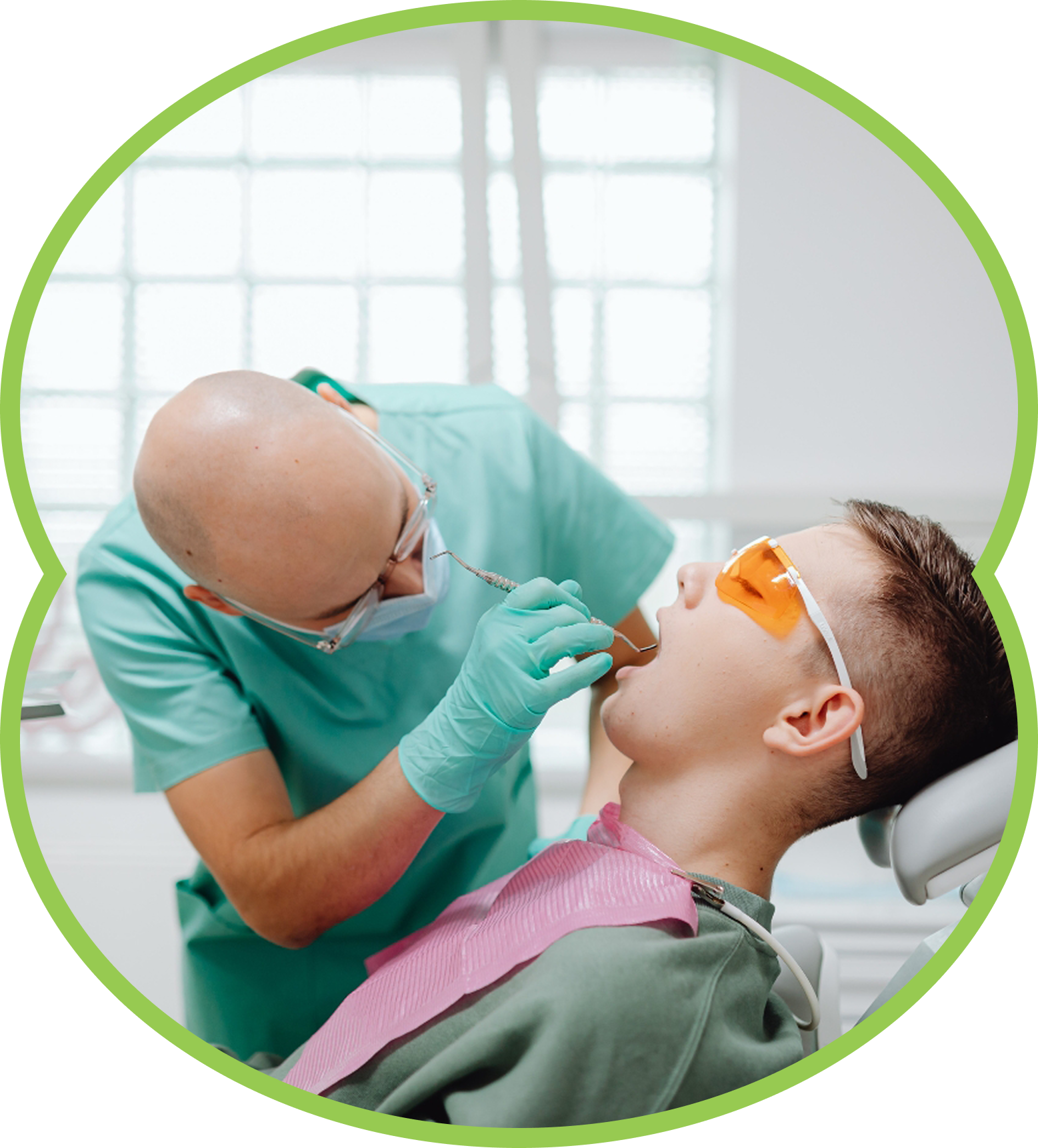 Dentist examining a patient in orange protective glasses during a dental procedure