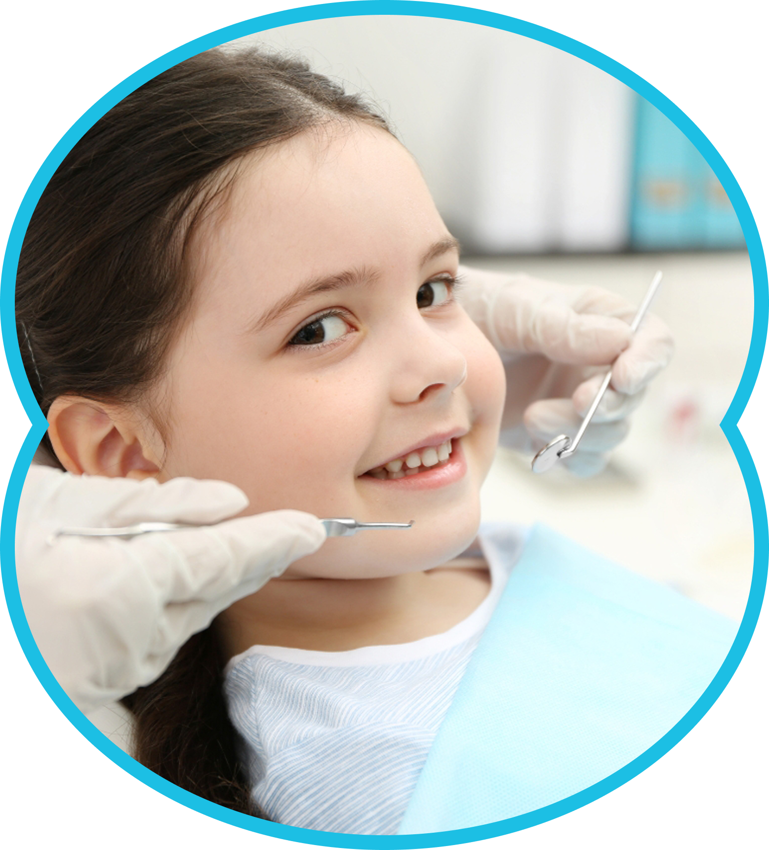 Smiling child at a dentist visit, with gloved hands and dental tools near her mouth.