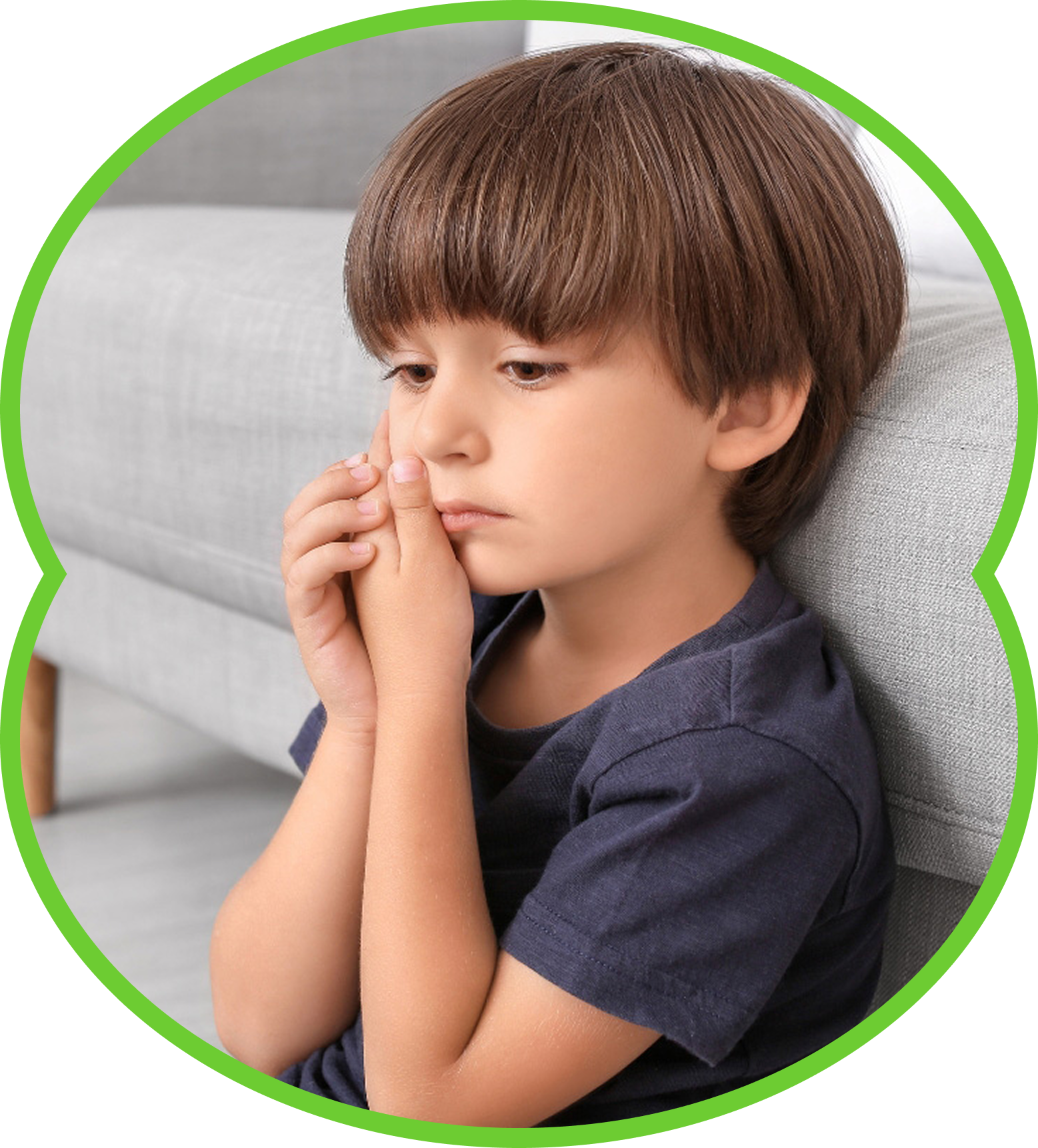 Child sitting on a couch, looking thoughtful with hands clasped near their face