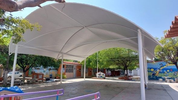 Una gran tienda de campaña blanca se encuentra en medio de un patio.