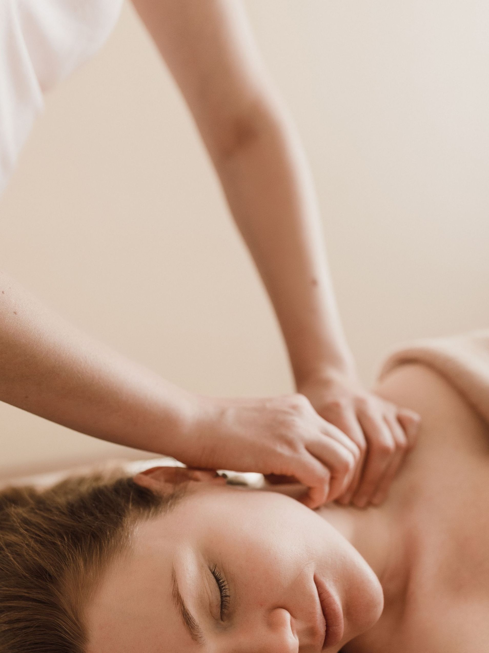 Close-up of a person receiving a neck and shoulder massage on a spa table