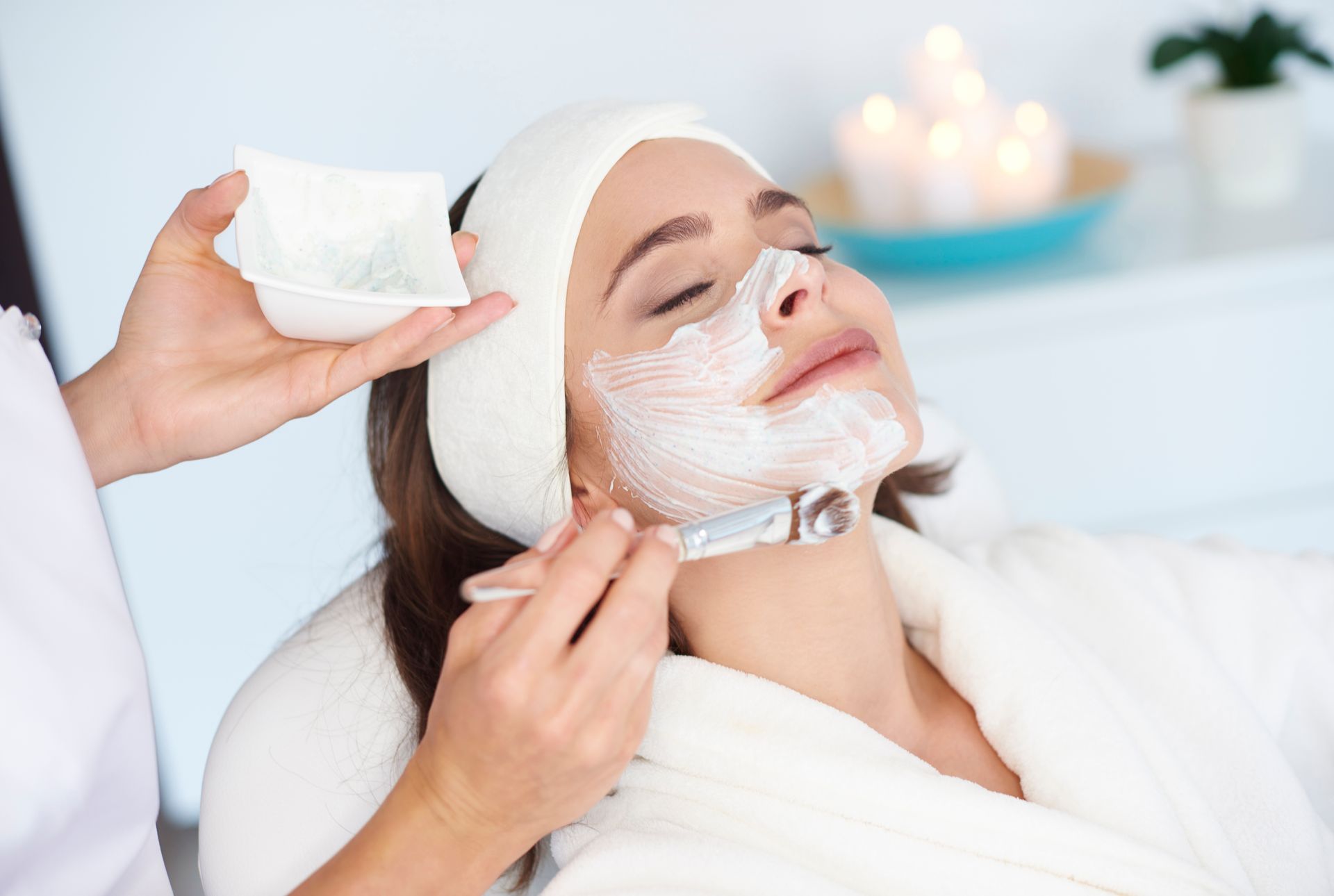 a woman getting a facial mask on her face