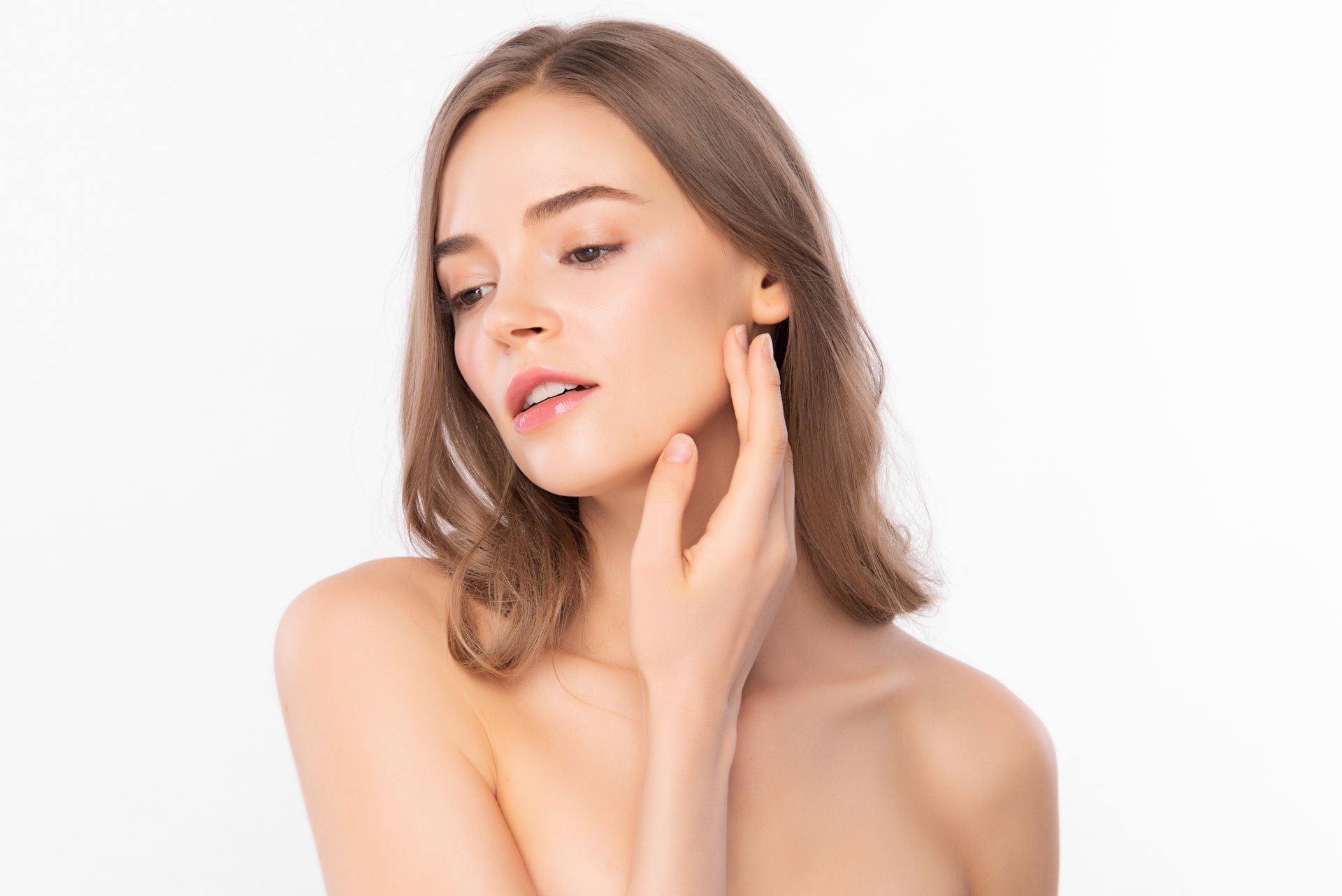 Close-up of a woman touching her cheek against a white background