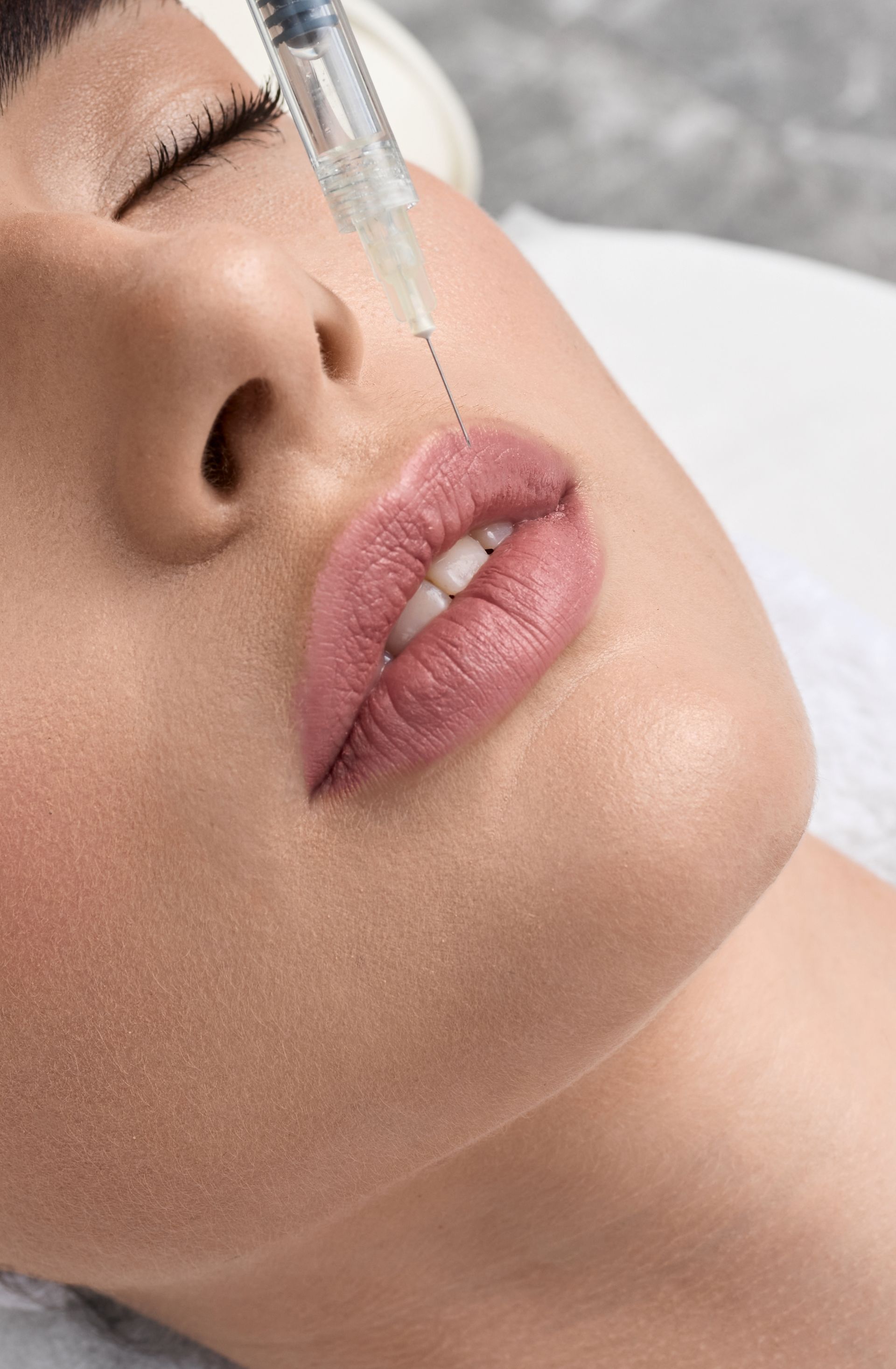Close-up of a person receiving a facial injection near the nose and lips