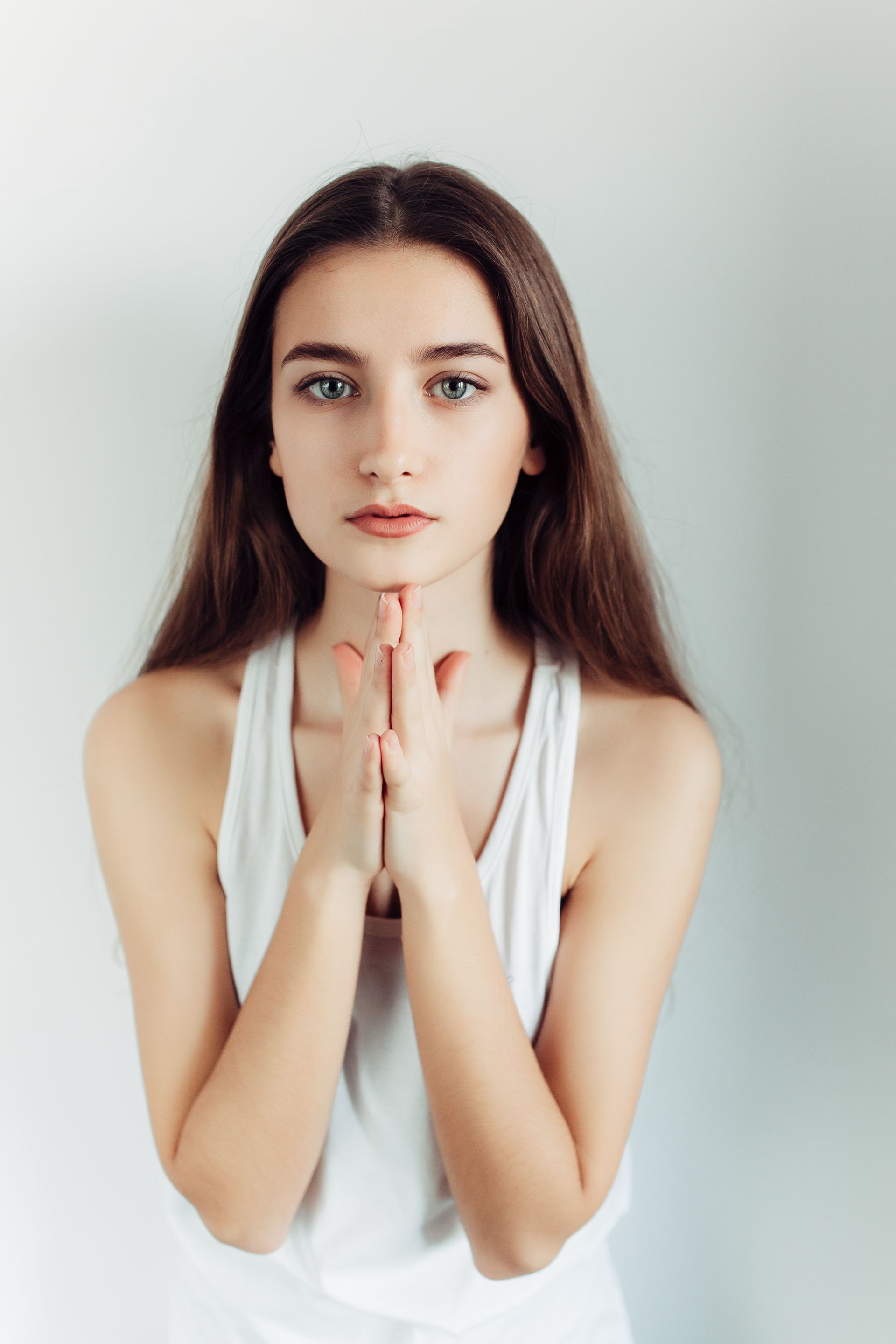 Gloved hands use a facial treatment device near a person’s closed eye and forehead.