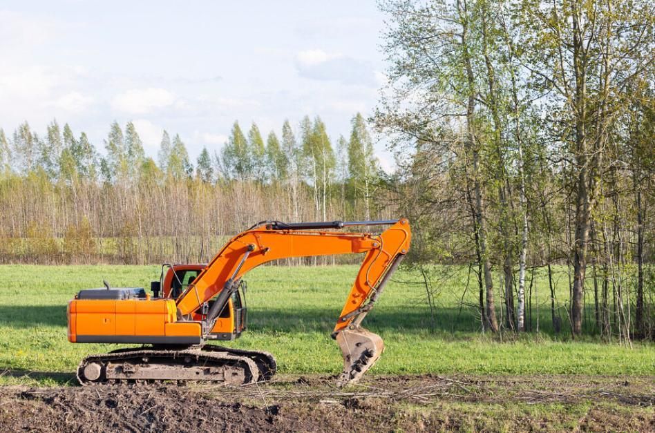 An Orange Excavator is Digging a Hole in a Field — J.A. Slashing in Smithfield, QLD