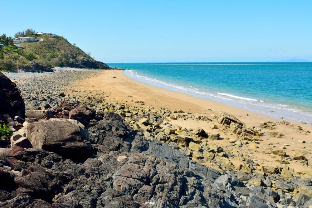 A Beach With a Rocky Shoreline and a Large Body of Water — J.A. Slashing in Palm Cove, QLD
