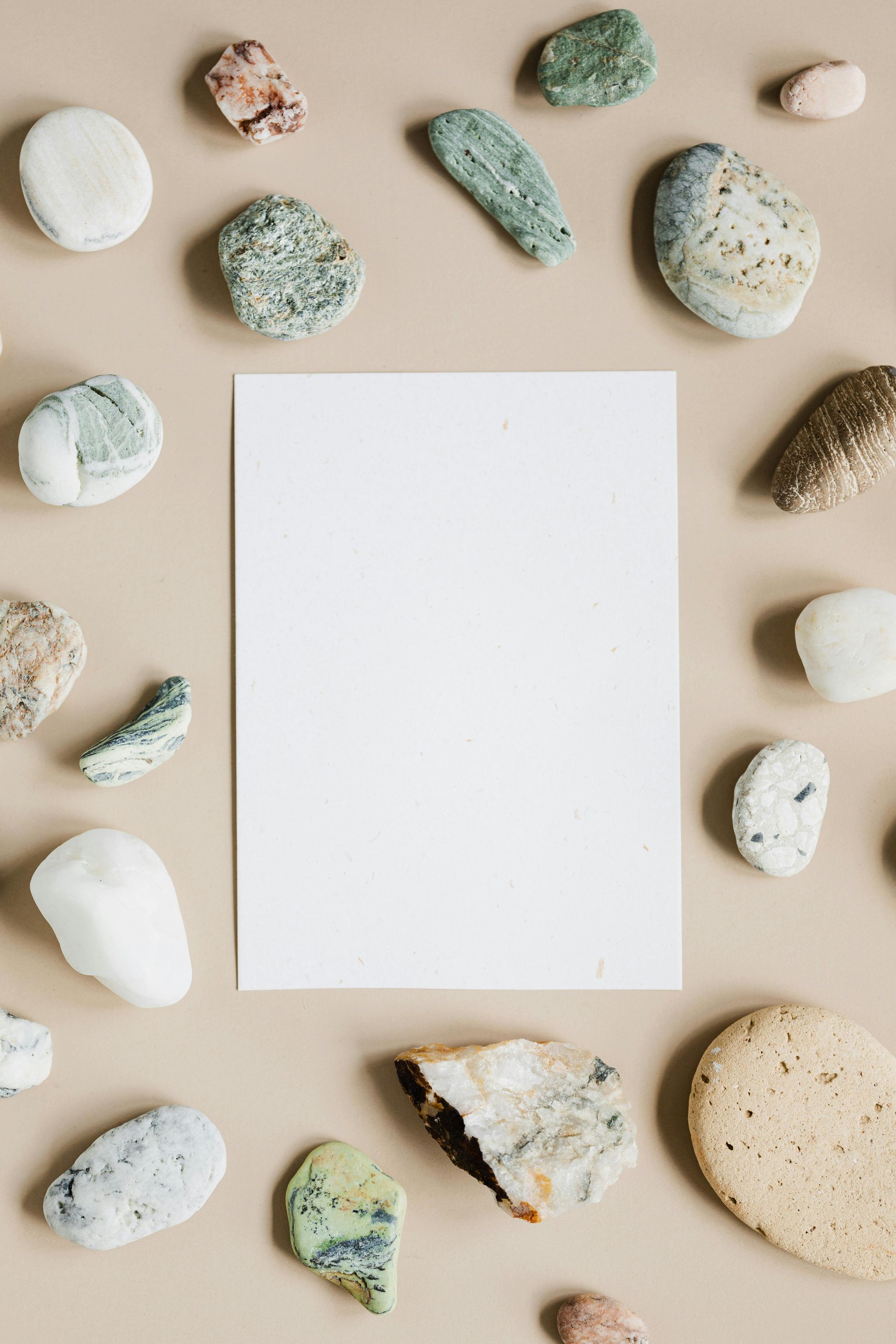 A white piece of paper is surrounded by rocks on a table.