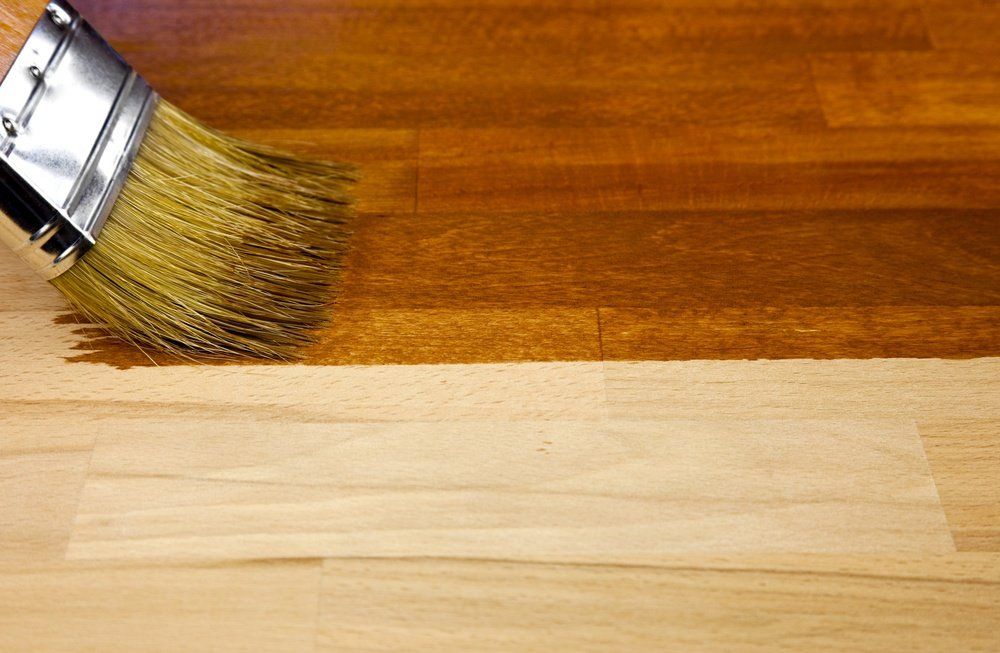 pennello nell'atto di verniciare e lucidare il parquet