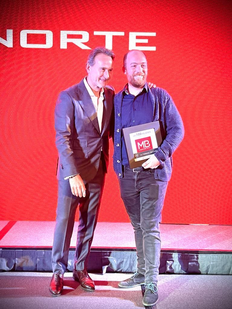 Dos hombres con placa en ceremonia premios