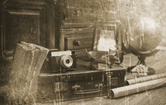A black and white photo of a suitcase and a camera.