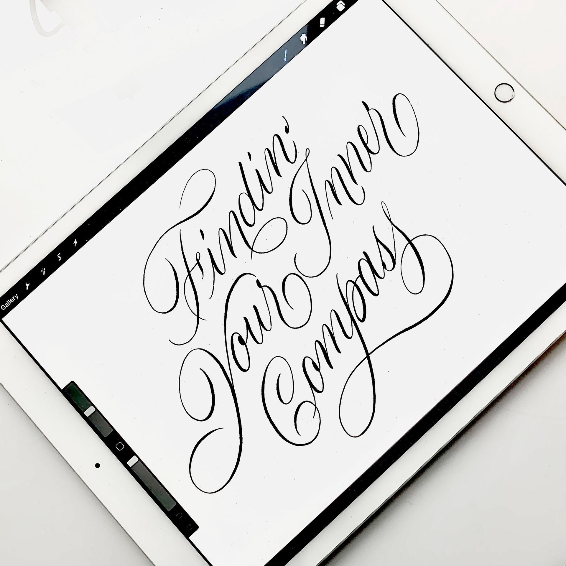 Brush script ipad lettering in black colour over a white background.
