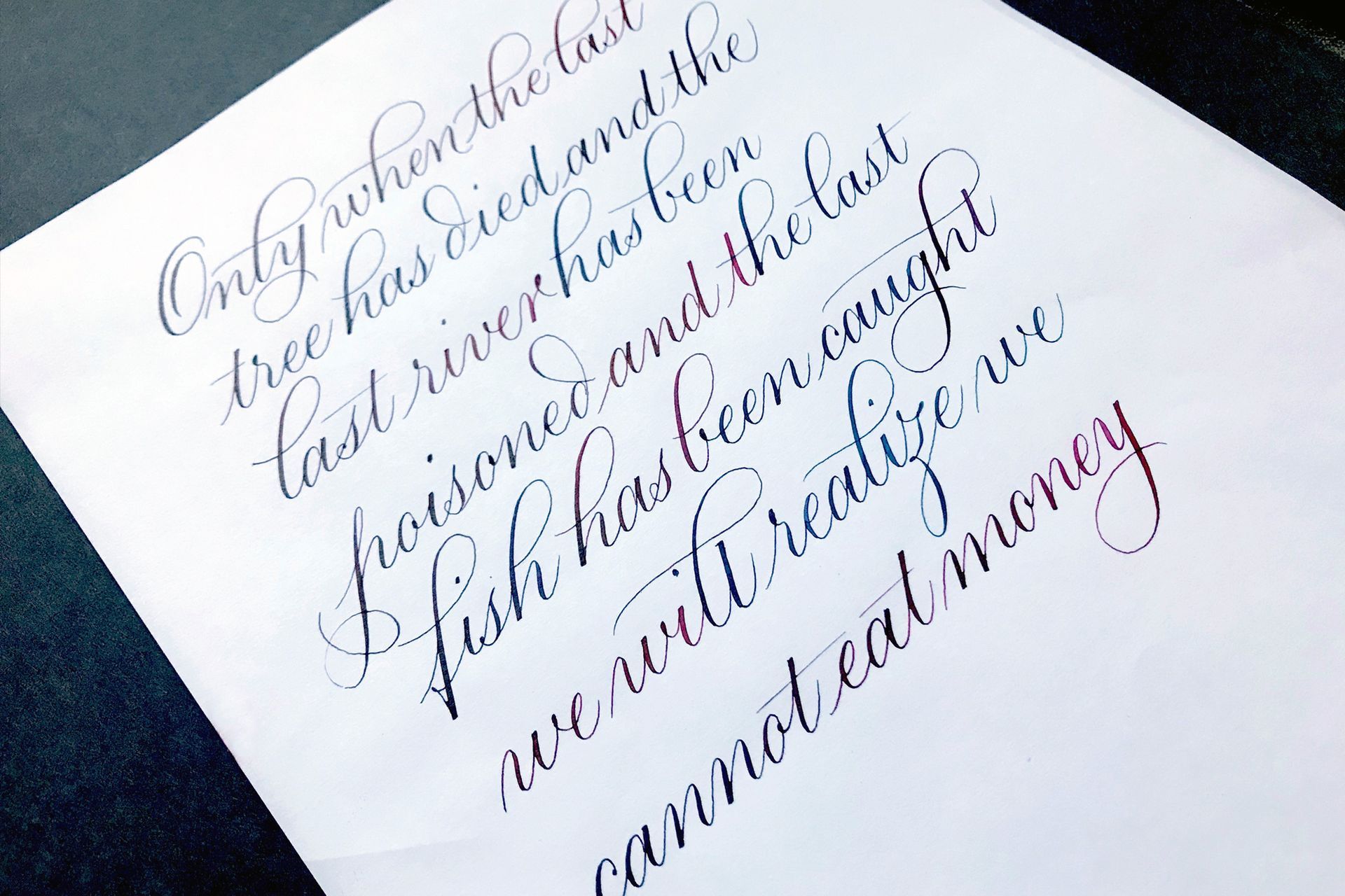 A Copperplate calligraphy piece displaying a long text using liquid watercolours to produce a beautiful gradient effect.