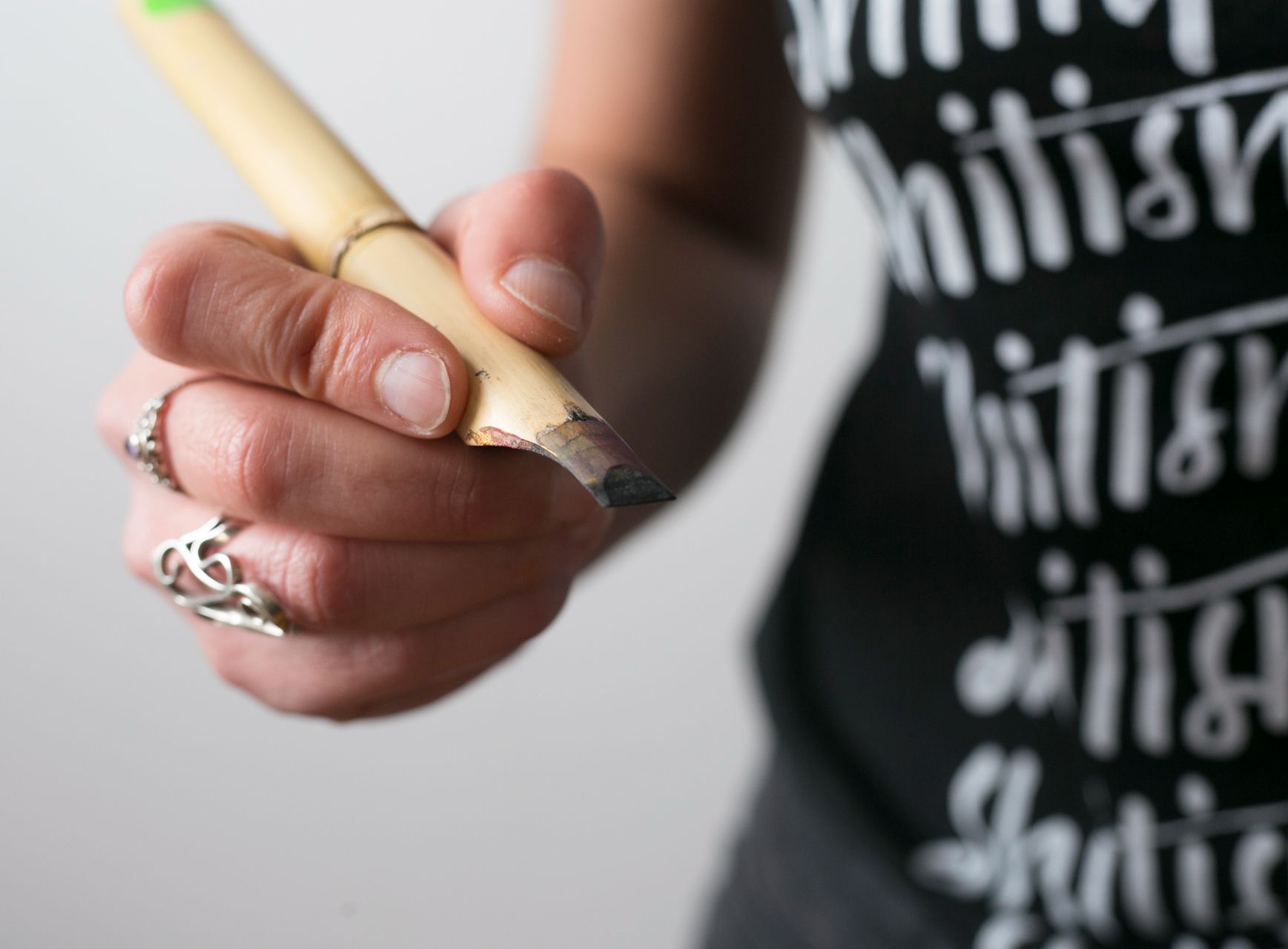 Maria Montes holding a bamboo pen for calligraphy.