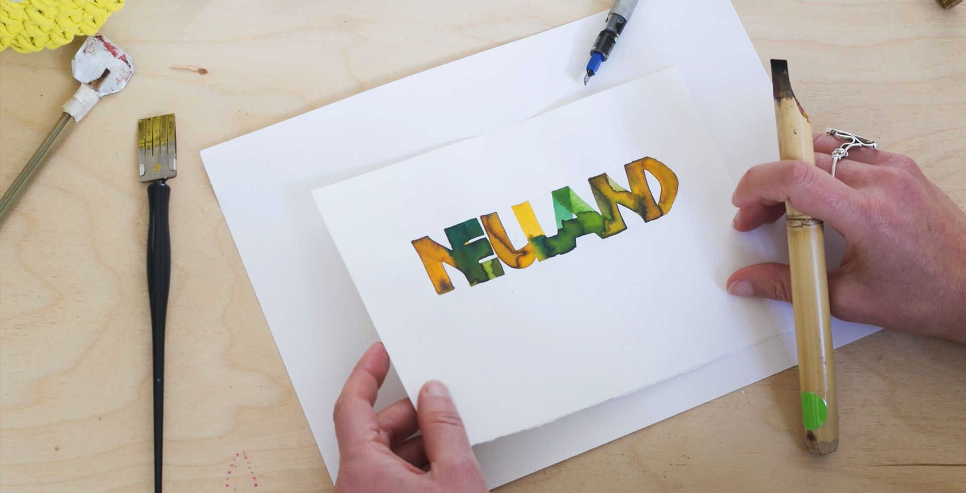 Neuland calligraphy piece with the message 'Neuland' using a yellow and green colour gradient.