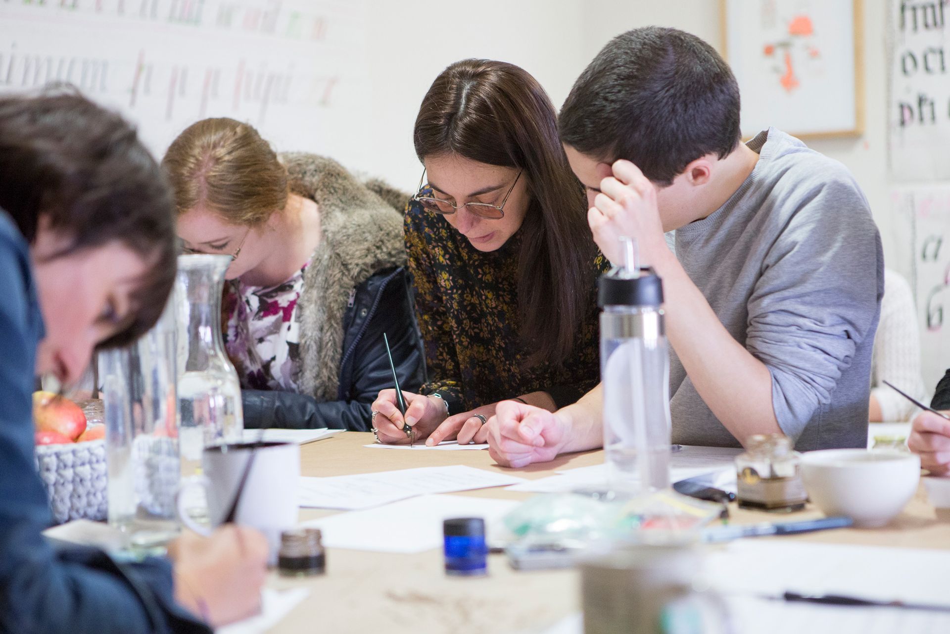 A photo of Maria Montes teaching calligraphy to a group of students at Rotson Studios.