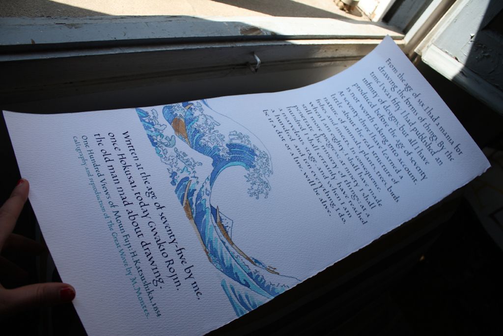 Handwritten pages with a blue wave drawing resting on a windowsill in sunlight