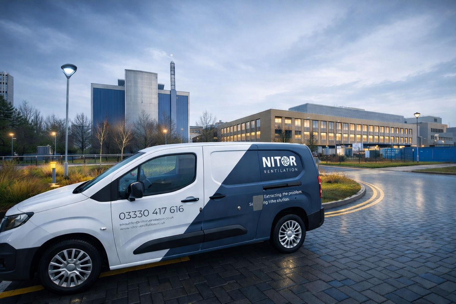 White and blue NITOR van parked near a modern building on a cloudy day.